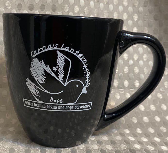 A black coffee mug with a white bird on it.