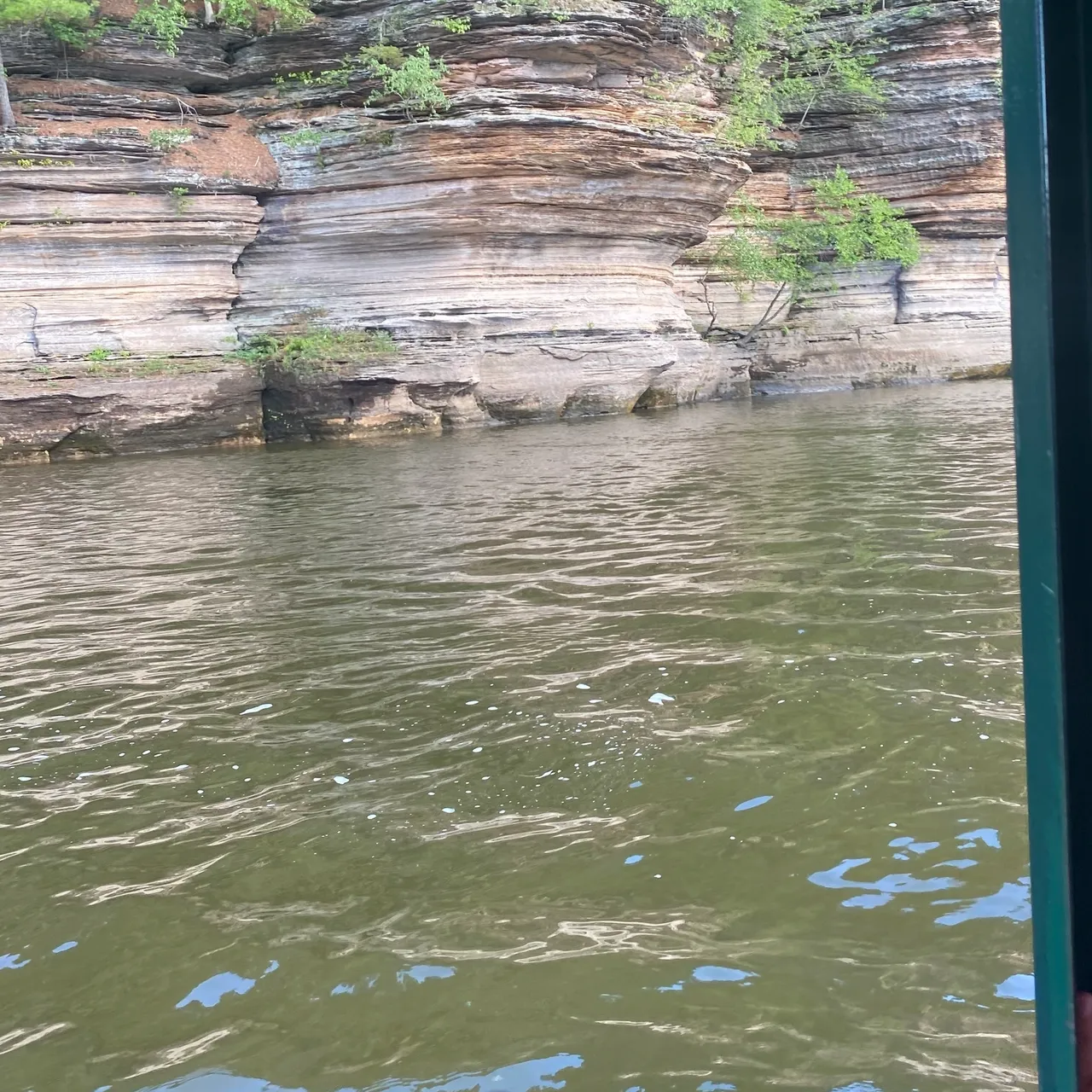 A body of water with trees and rocks in the background.